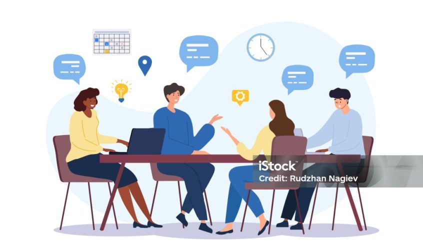 Four coworkers sit around a table in a meeting, sharing ideas with speech bubbles and floating icons such as a calendar and lightbulb.