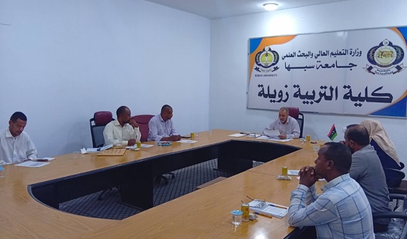 Six men sit around a U-shaped wooden conference table in a meeting room, with papers and yellow drinks on the table; a large Arabic banner hangs on the wall behind them.