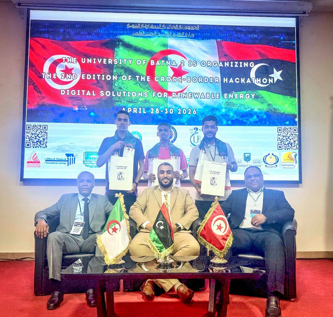 Winners pose with certificates on a stage at the Cross-Border Hackathon 2026 in Batna; three flags (Algeria, Libya, Tunisia) on the table in front of them.