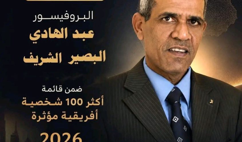 مُنشور دعائي سياسي بالعربي يعرض رجلًا في بدلة وربطة عنق؛ مع نصوص باللغة العربية تُعلن عن إنجازٍ ليبي وتفاصيل الحملة و2026 وشعار 'Powered by Africa'