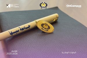 Pen with Arabic text resting on a textured notebook, flanked by logos, promoting the national championship season 2025–2026.
