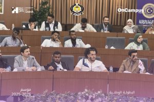Panel of participants seated at a conference table with microphones, banners and OnCampus logos in the background; Arabic text shows season 2025–2026 and national championship.