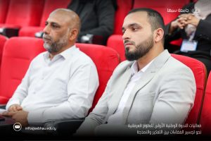 Two men in business attire sit in red theater chairs during a formal event; an Arabic caption and university logo appear in the lower right, with a contact email visible at the bottom left.