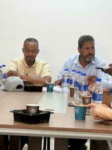 WhatsApp Image 2026-07-12 at 11.32.21 PM (1) - جامعة سبها | Sebha University Group of men seated around a conference table with water bottles, cups, and snacks during a meeting.