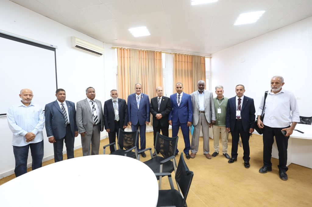 Group of professionally dressed men standing in a conference room, posing for a group photo.