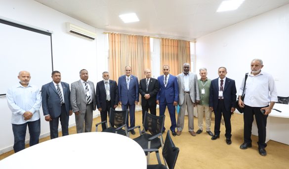 Group of professionally dressed men standing in a conference room, posing for a group photo.